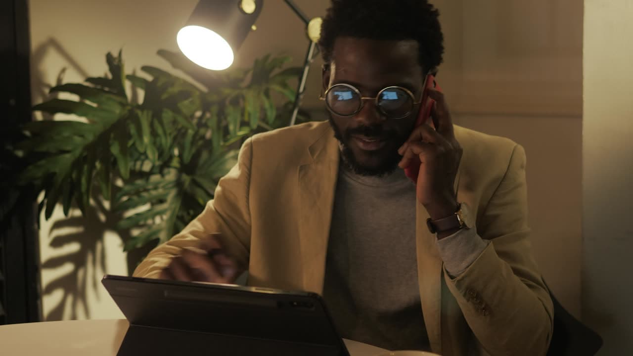 A business owner on a phone call while working on a tablet