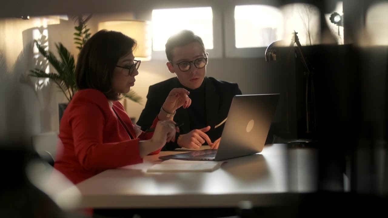 An attorney and client discussing a matter over a laptop
